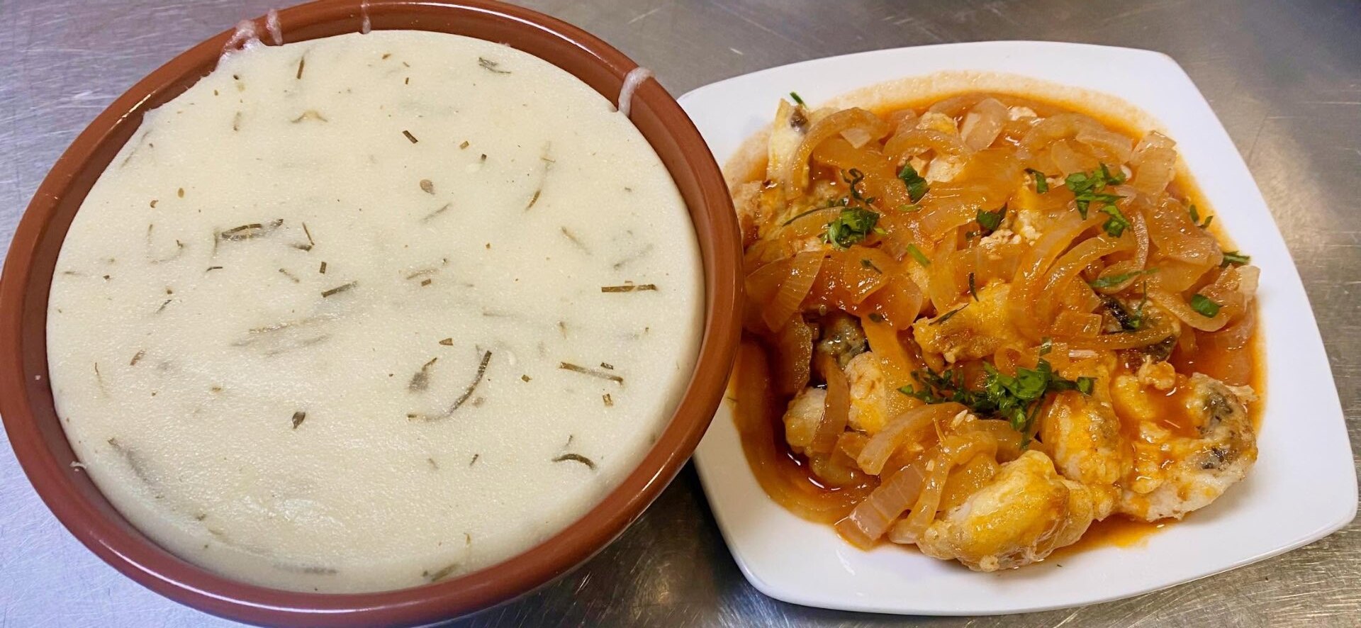 Salt cod with onions alongside a clay dish of açorda