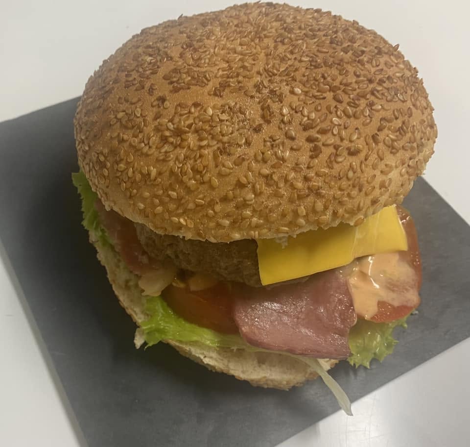 House burger with cheese, bacon and salad on a sesame bun