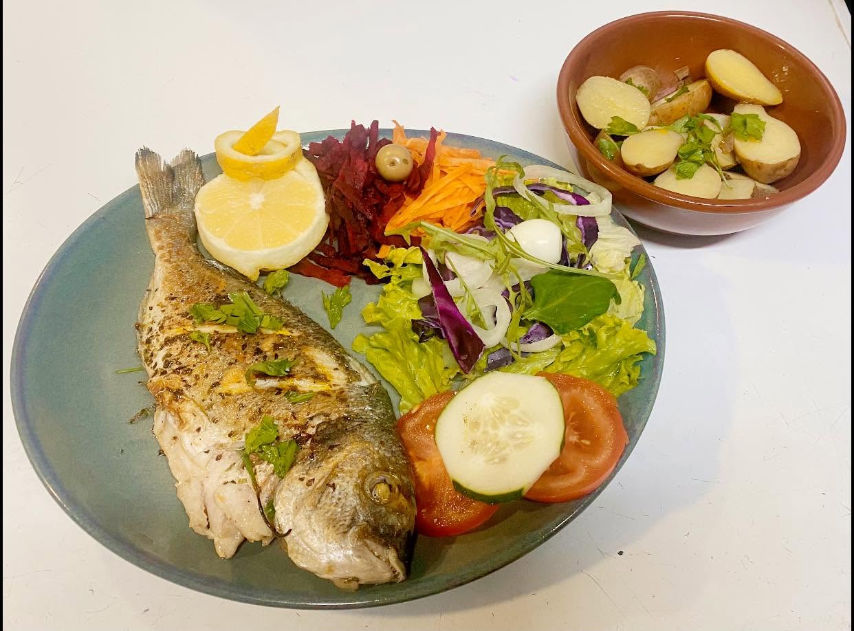 Whole grilled sea bream with salad and boiled potatoes